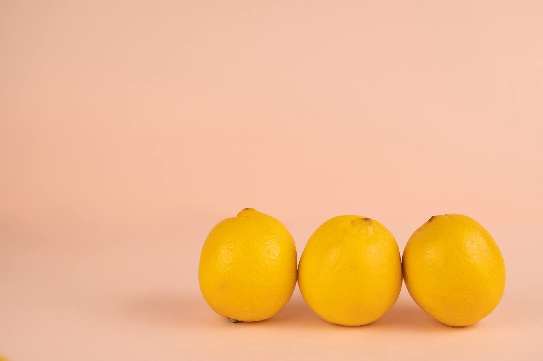 Bright ripe lemons on a pastel background representing fresh self-care and pleasure